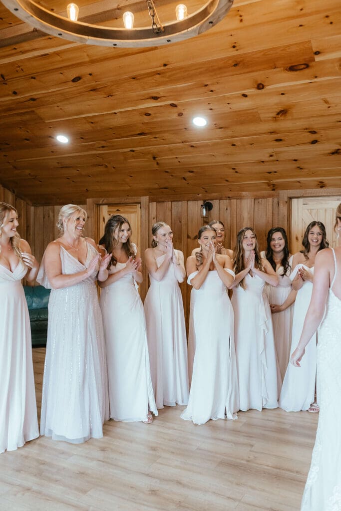 Bridesmaids smile as they see the bride for the first time on the morning of her wedding day