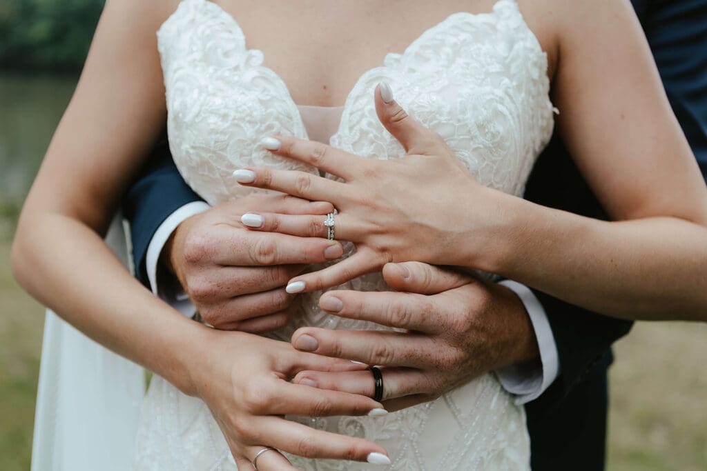 Close up of bride groom's hands touching their wedding rings