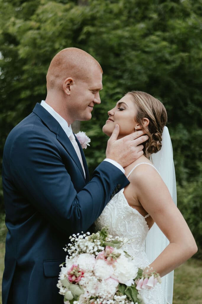 Groom touches bride's face as they stare lovingly into each other's eyes