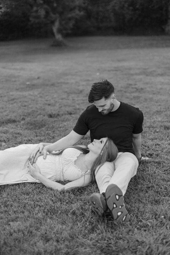 Woman lays her head on her husband's lap and stares lovingly into his eyes