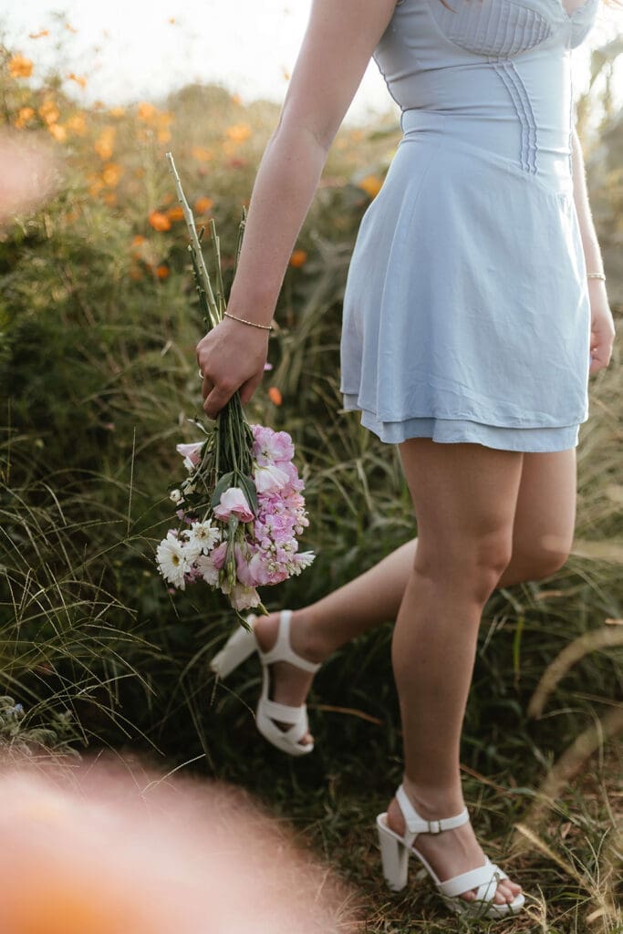 Girl in blue dress holds a bouquet of flowers