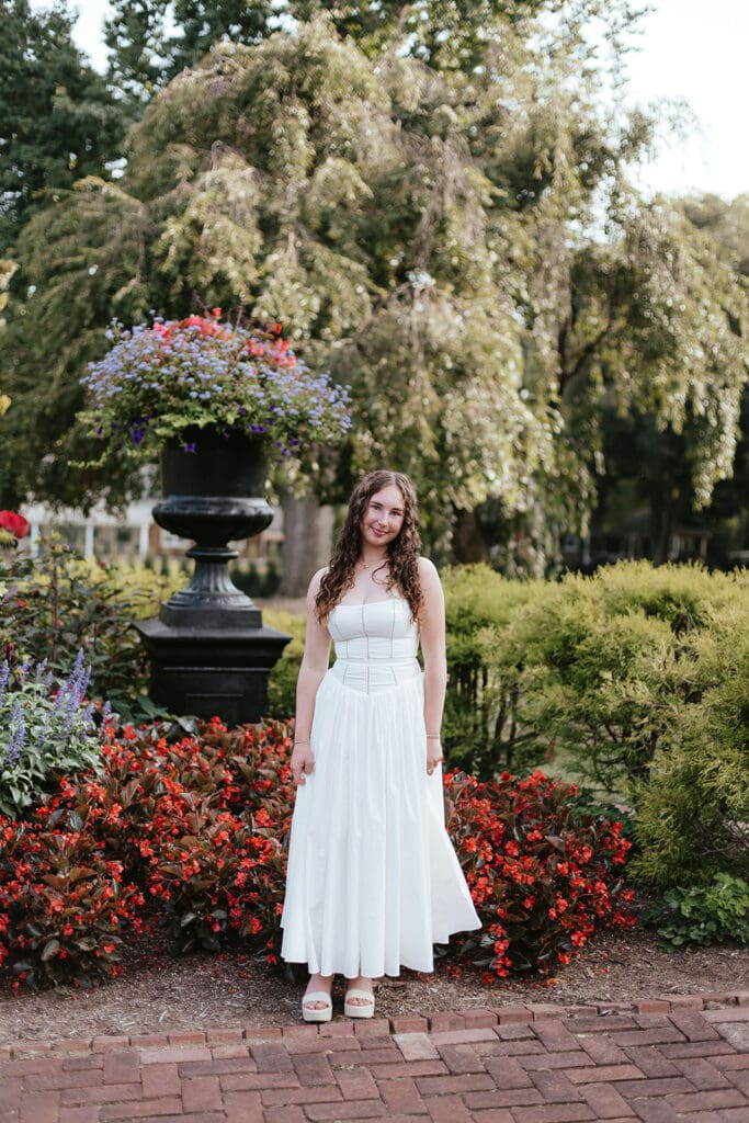 Senior portrait in front of a garden of flowers
