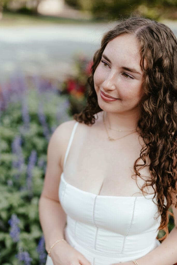 Senior portrait in front of a garden of flowers