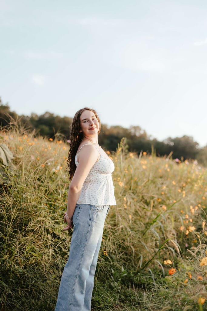 Senior portrait during golden hour in a field of wildflowers