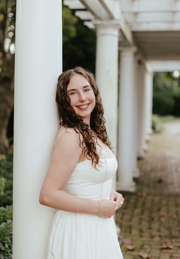 Senior portrait of girl leaning against a white column