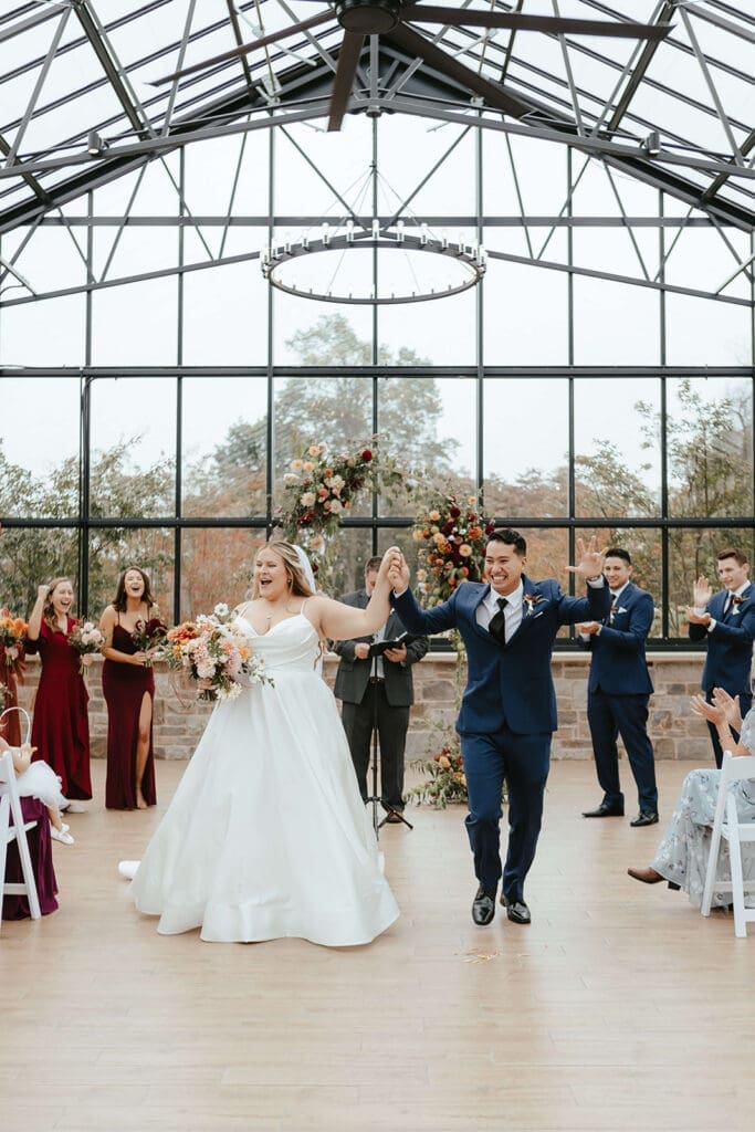 Bride and groom celebrating their marriage in the greenhouse at Westwynd Gardens