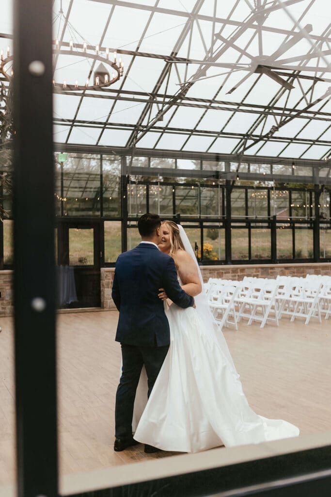 Bride and groom share an intimate kiss in the greenhouse