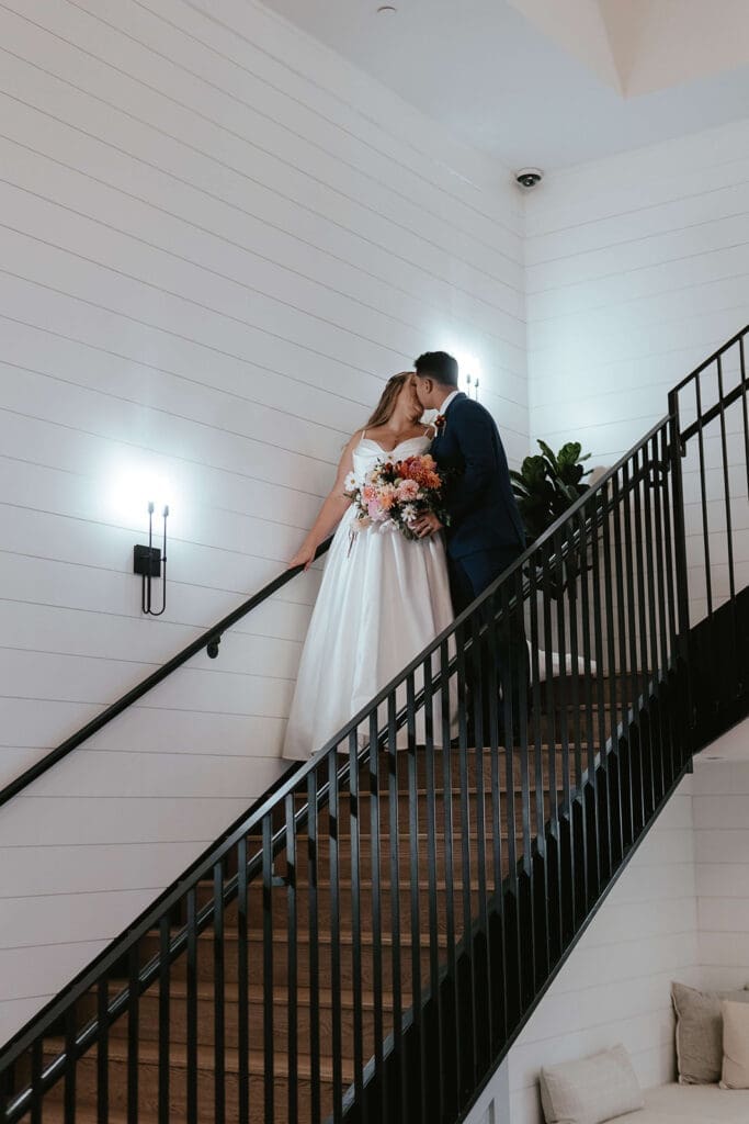 Bride and groom kissing on a staircase