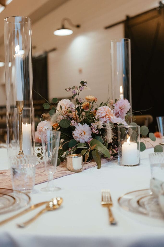 Candlelit wedding reception table with blush pink flowers