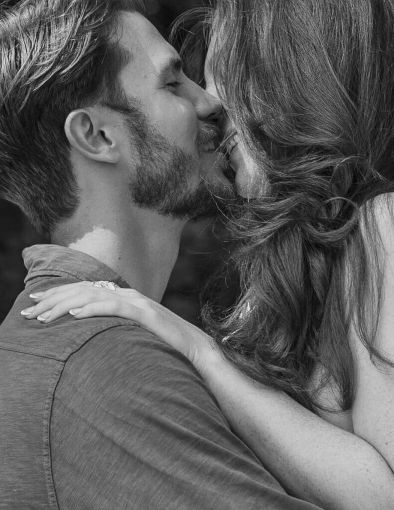 Up close candid of an engaged man and woman kissing