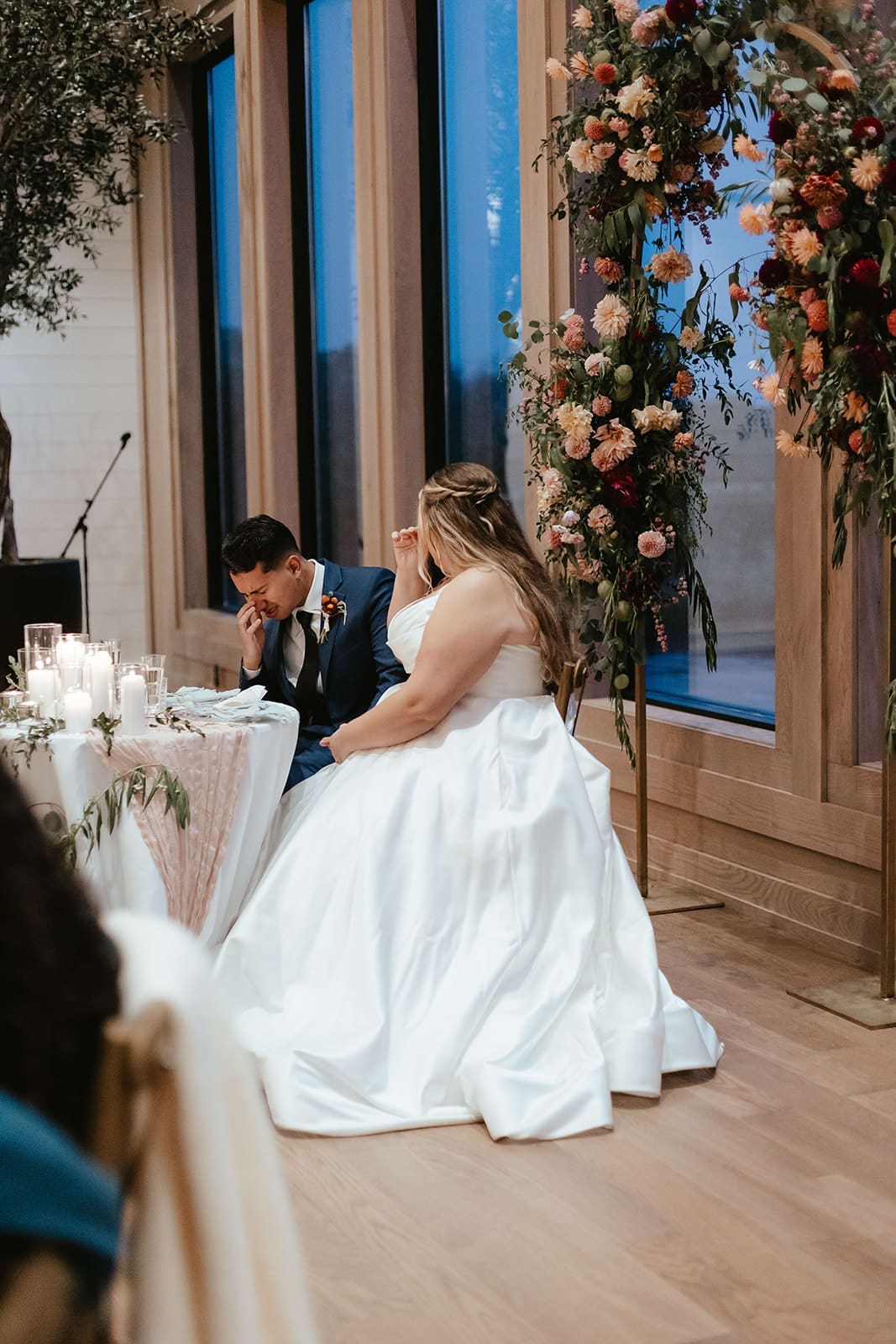 Bride and groom crying during an emotional speech