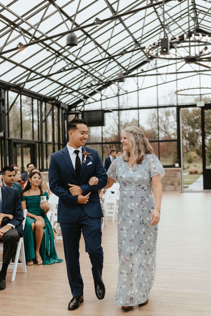 Groom escorting the mother of the bride down the aisle