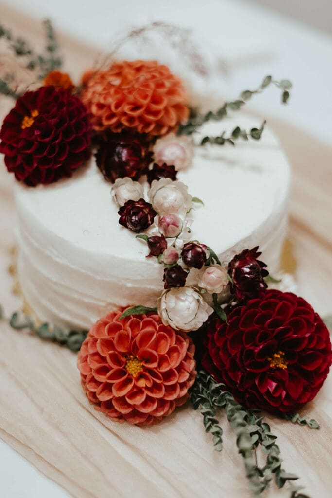 White wedding cake topped with earthy fall flowers