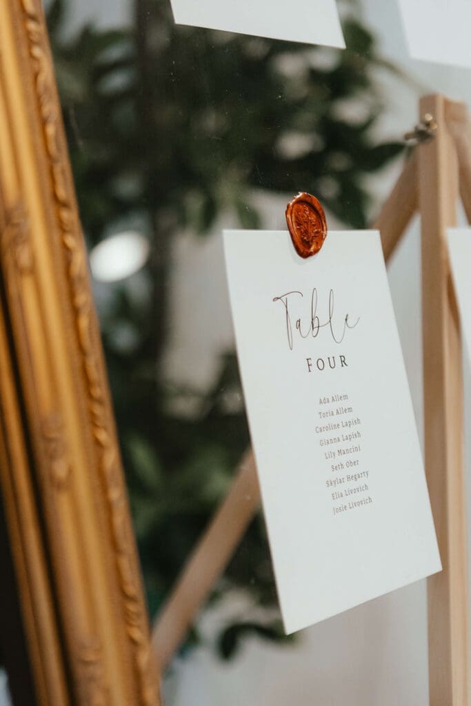 Wedding seating chart display on a mirror with wax seal