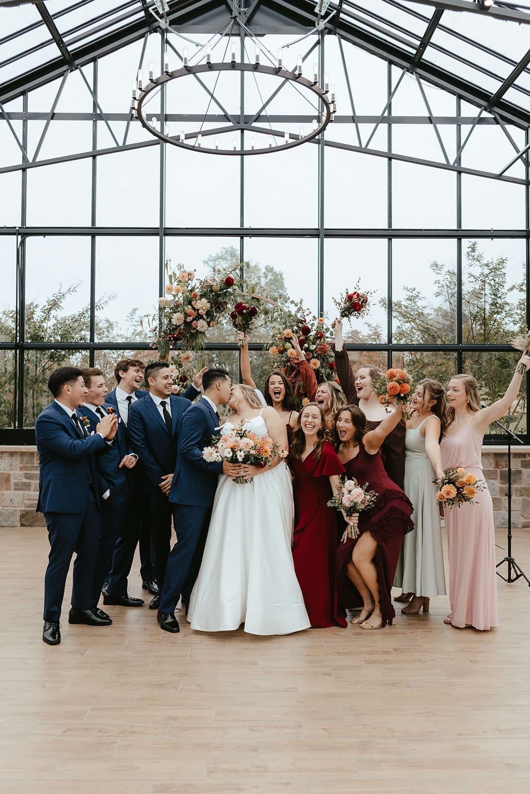 Bride and groom kiss as their wedding party celebrates