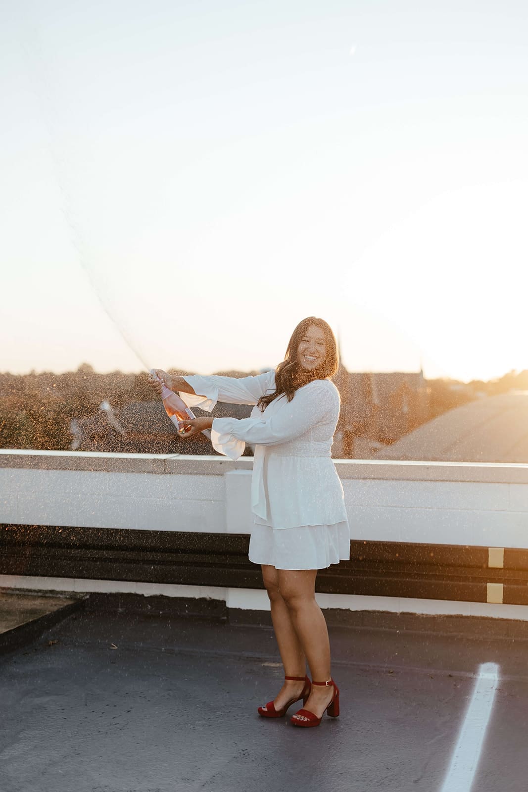 Senior spraying a bottle of champagne to celebrate her graduation