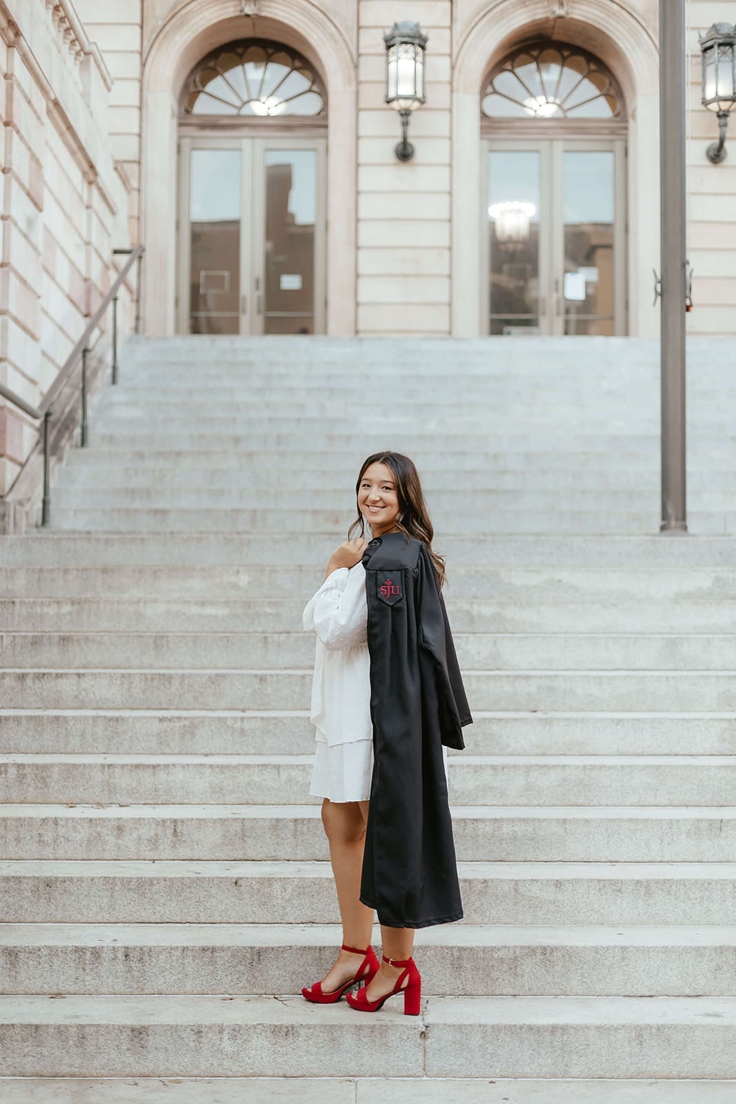 Saint Joseph's University college graduate with gown on the steps of Lancaster County Courthouse