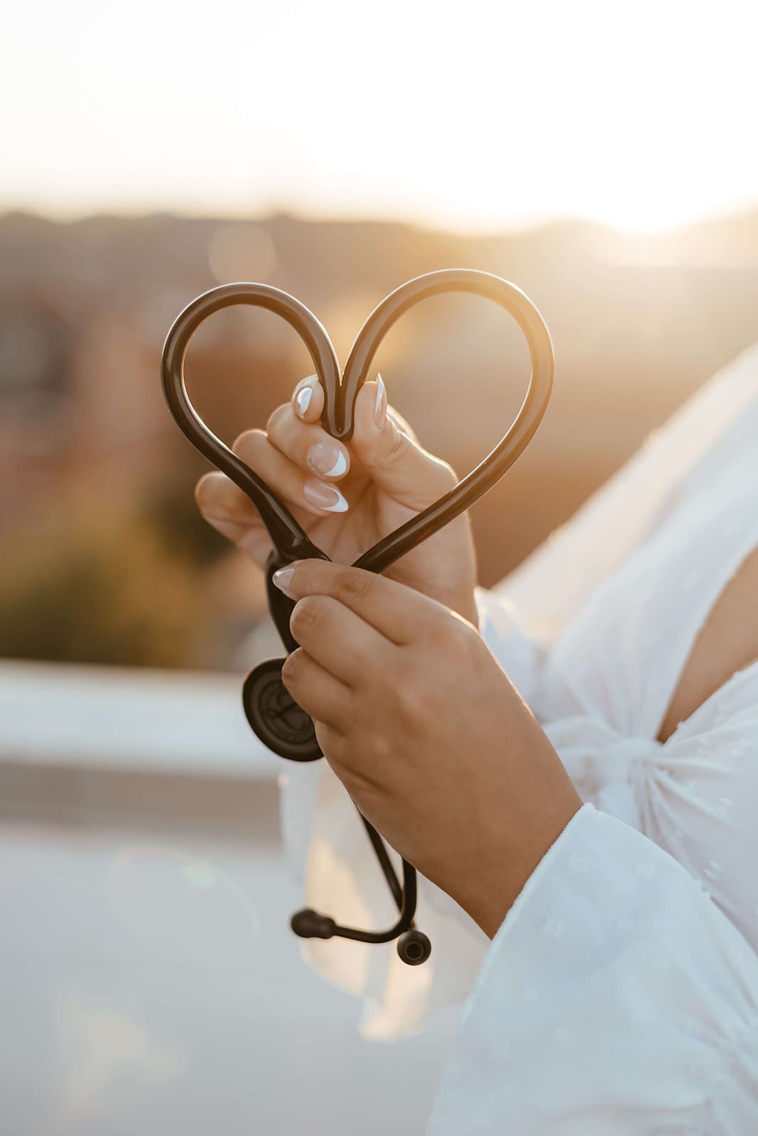 Nursing student holding stethoscope in the shape of a heart to celebrate her graduation