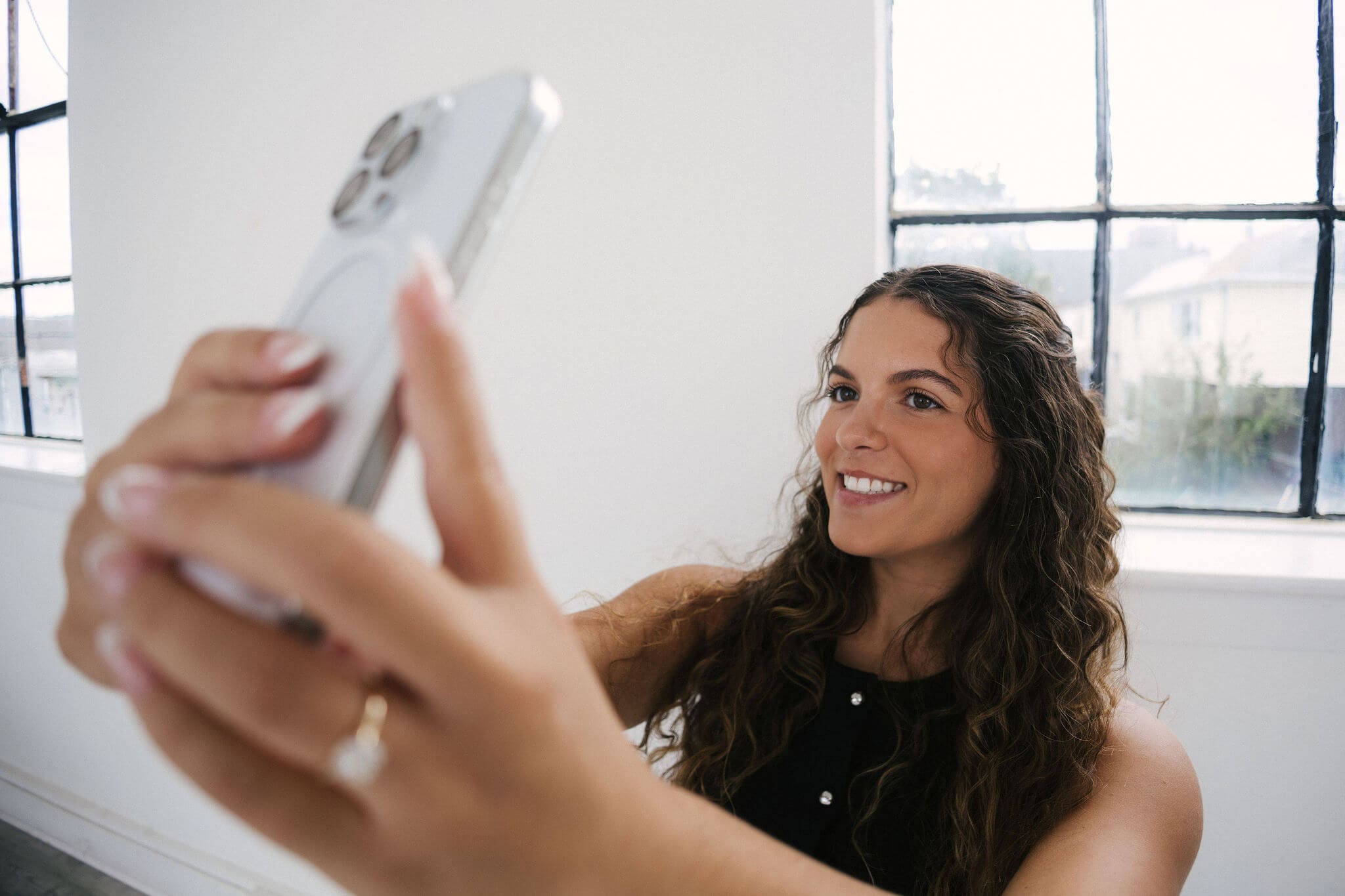 Wedding content creator Johanna Rose Creative smiling while taking a selfie on her iPhone